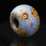 Glass bead with mosaic cane eyes